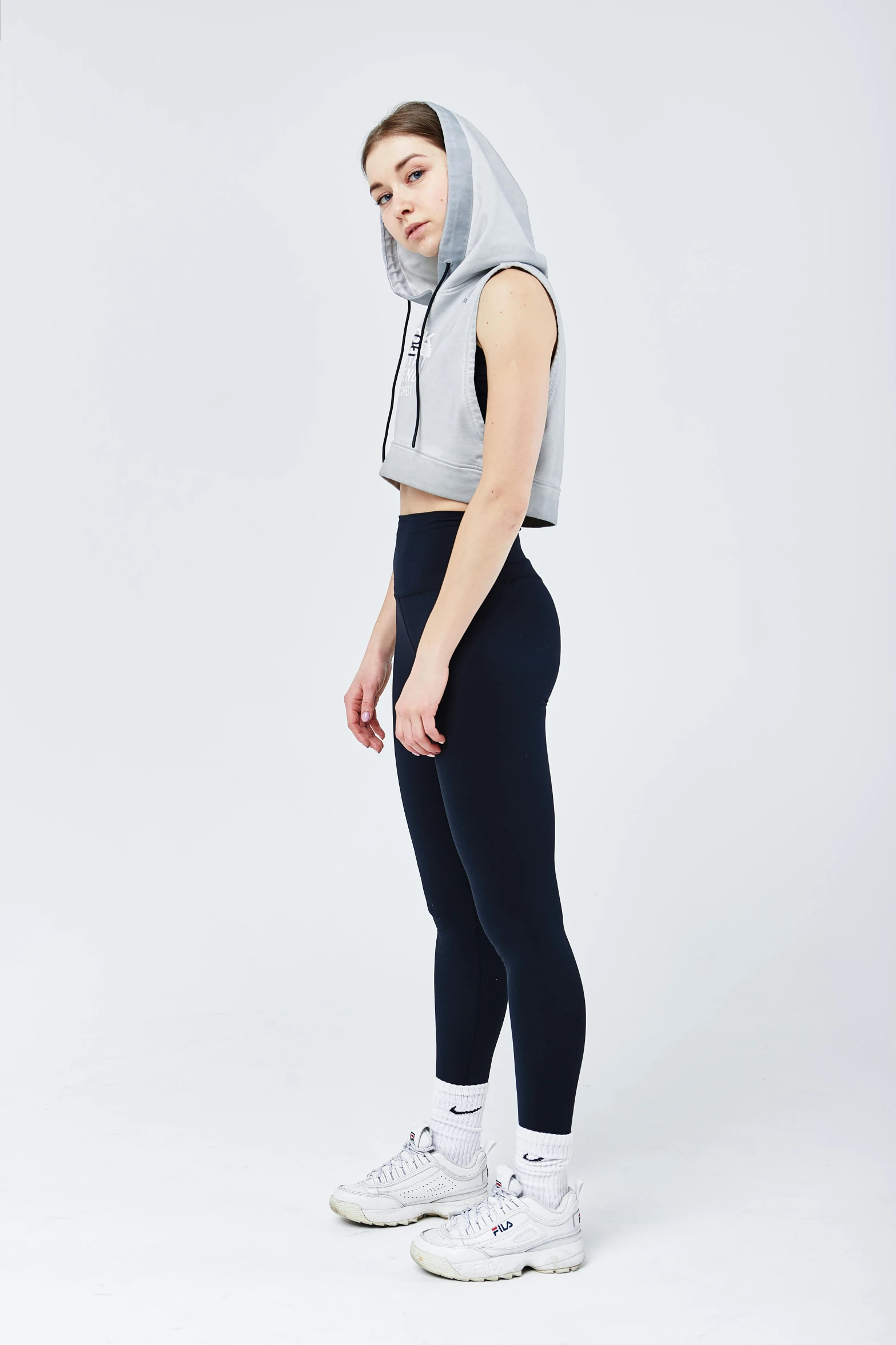 a girl in white shirt and black pants with hood