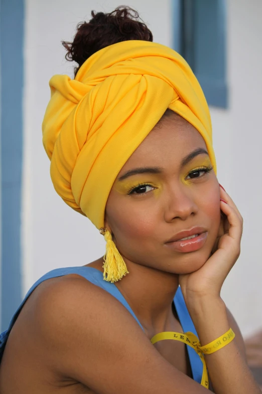 a woman in blue is wearing a yellow turban