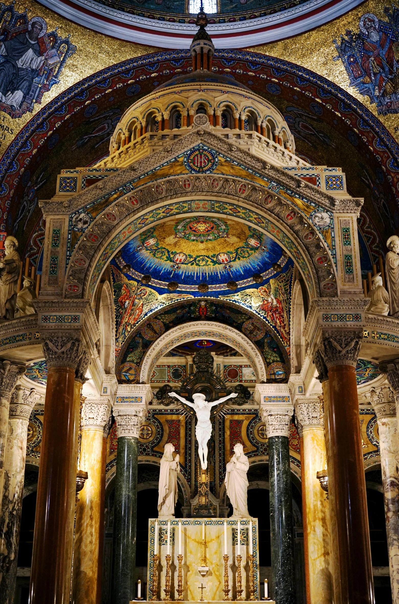 some statues in an ornate building under a blue and yellow ceiling