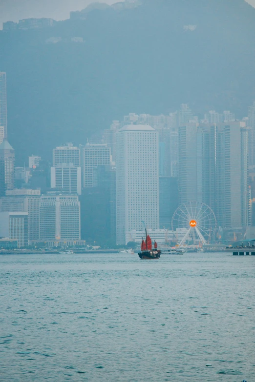 a boat floating on top of the ocean in front of a city