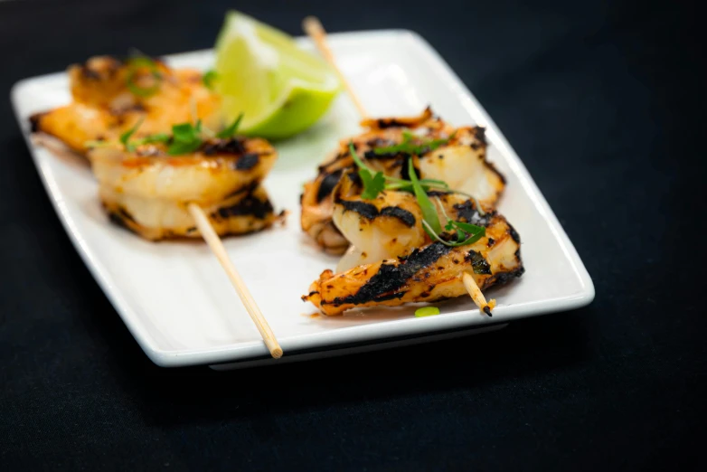 grilled fish are served on a square plate