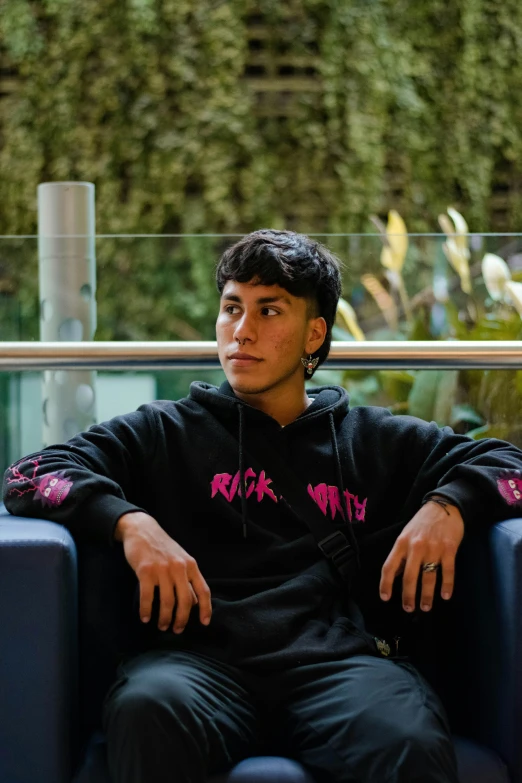 a young man sitting on top of a couch near tall buildings