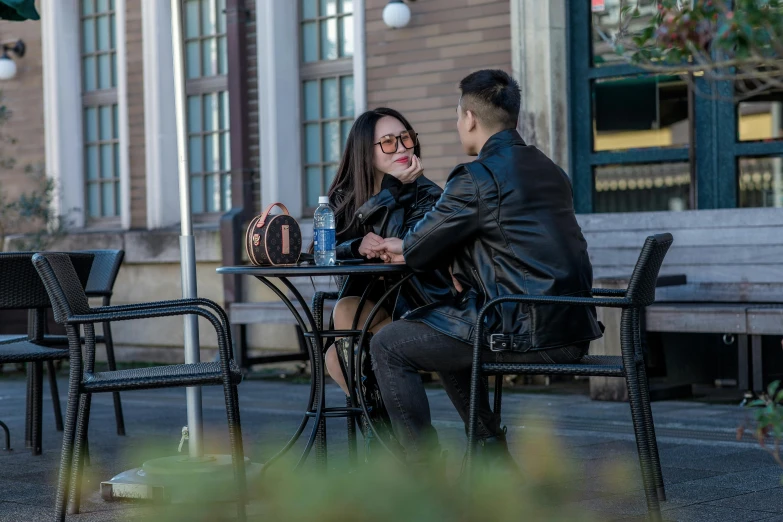 two people sitting at a table and talking