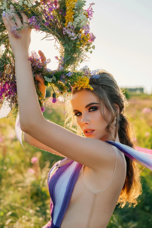 a beautiful young woman in a striped bathing suit holding flowers