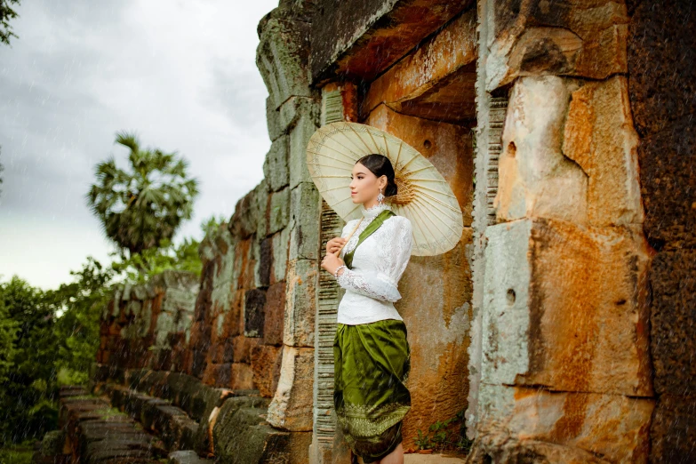 a woman standing on a stone steps holding an umbrella