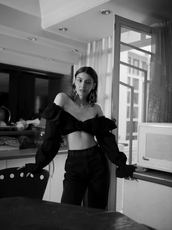 a woman is posing in an empty kitchen