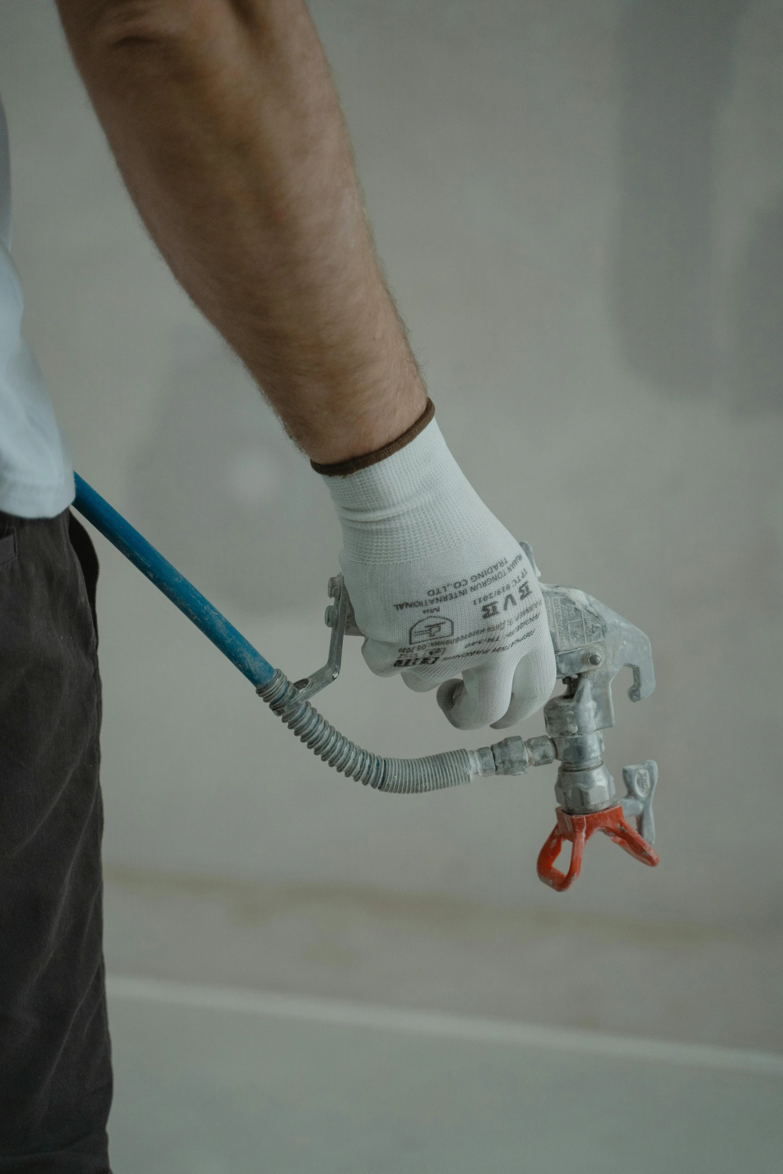 a person in white gloves holding a pliers and scissors