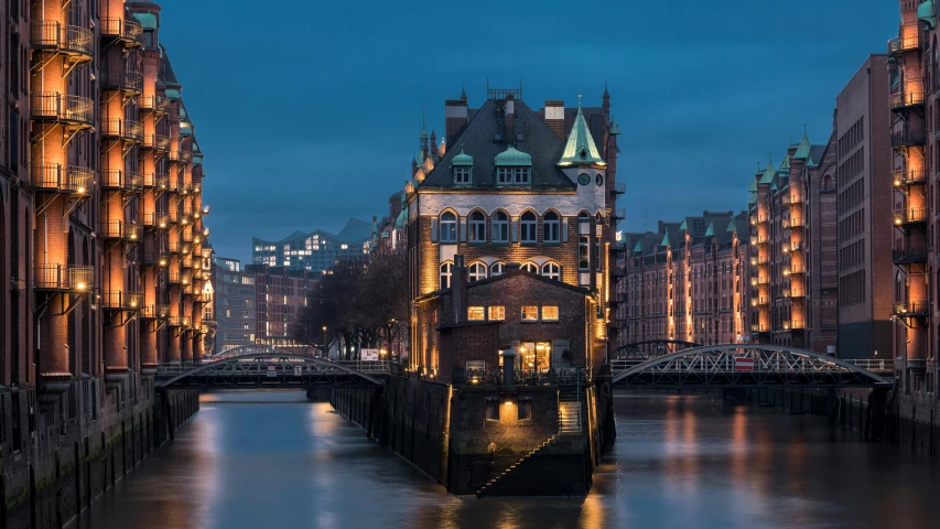 a night scene of a river running between two buildings