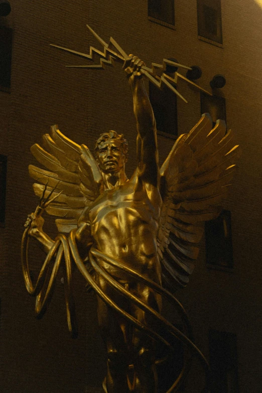 a gold statue holding the cross and sword of jesus