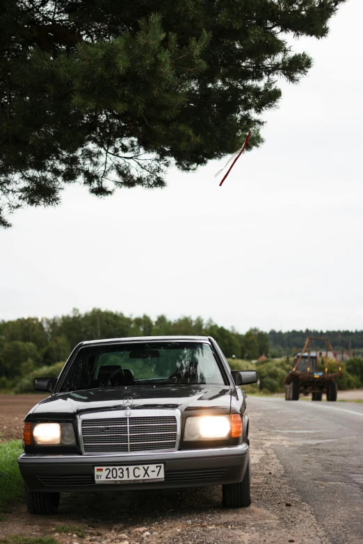 a mercedes benz benz benz car parked in the shade of the tree