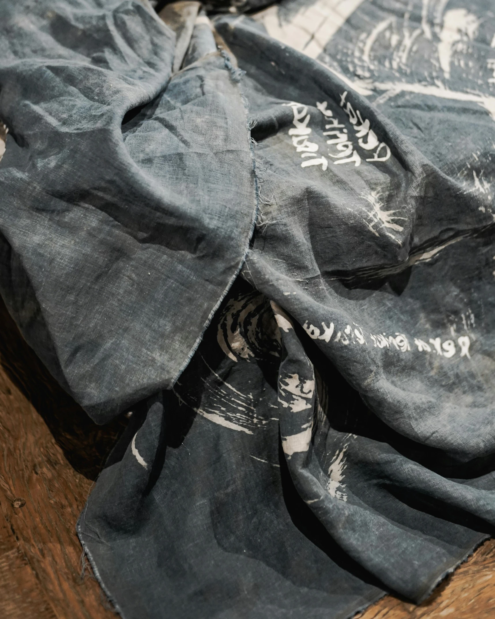 an un - sewn pair of black jeans lie next to an old t - shirt