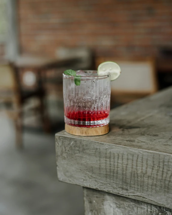 a small drink in a glass is shown with red liquid