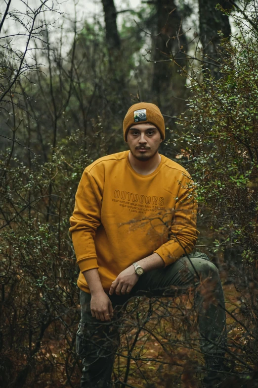 the man is sitting on a stump outside