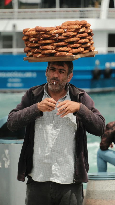 there is a man with a basket on his head and all of his food piled on his head