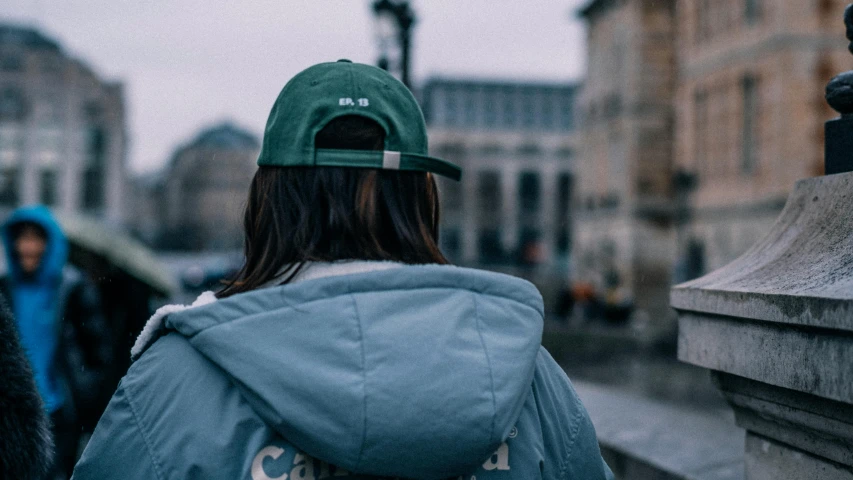 a young person is walking on the city street in the rain