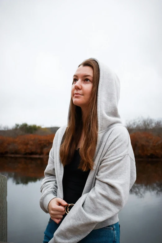 a beautiful young woman leaning against a wooden rail