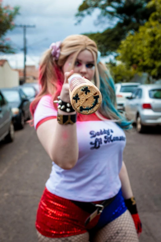 a girl in red shorts and a white t shirt is holding a brown object