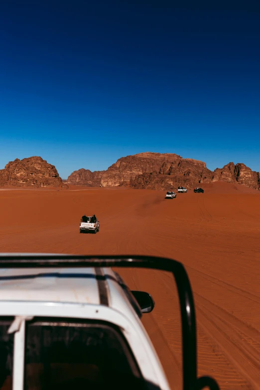 two off road cars driving on the sandy beach