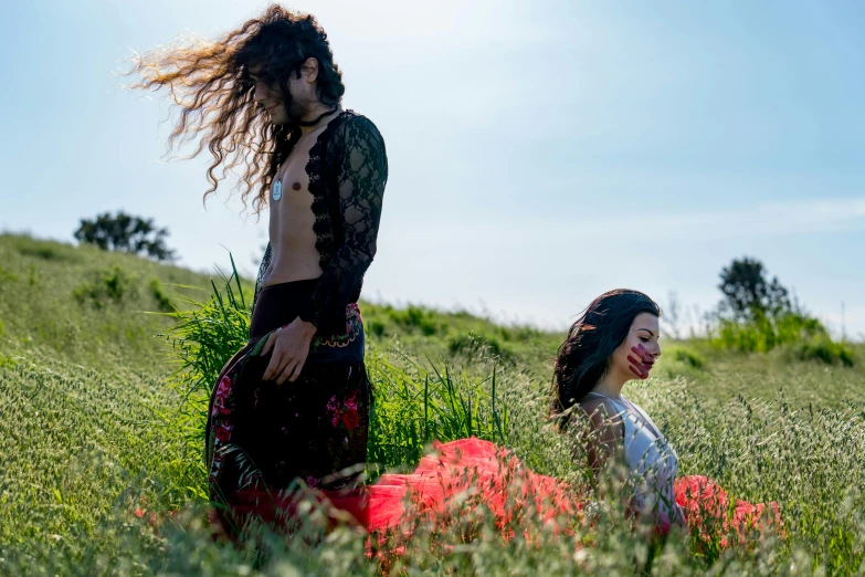 a woman sitting on the grass with another person