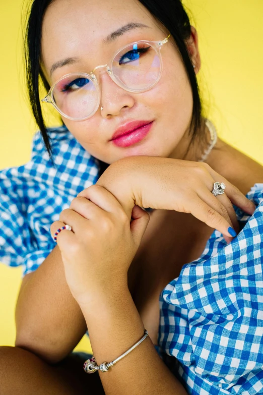 a woman is sitting down with her hand on her chin