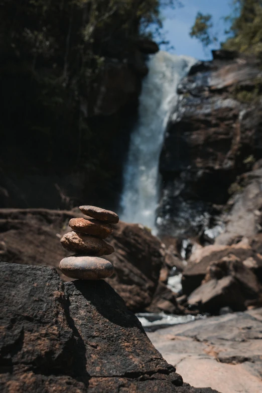 rocks stacked on top of each other in front of a waterfall