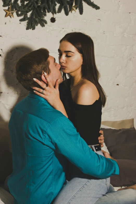 the man and woman share a kiss on the couch