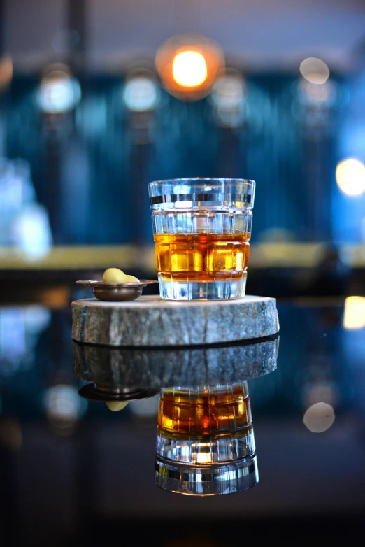 two s glasses filled with drink sit on a table