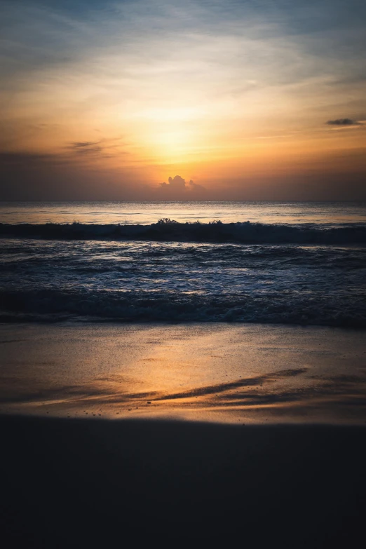 sunsets with waves in foreground and the sun setting