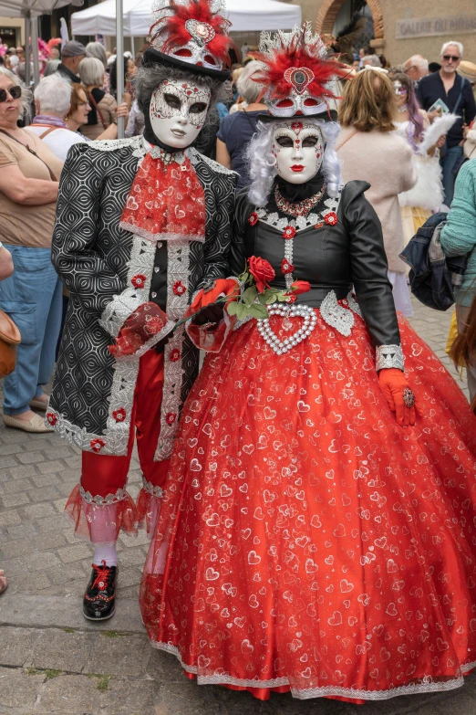 two people dressed up in fancy costumes and red outfits