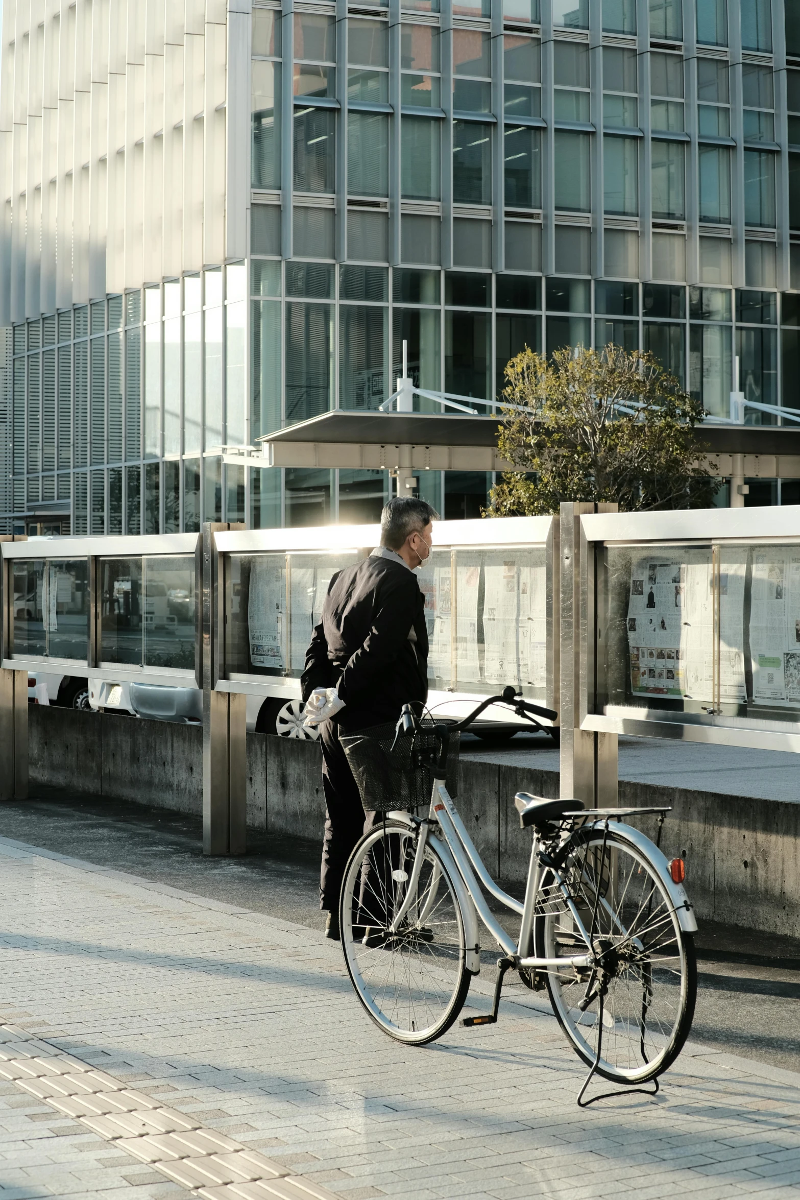 a man stands next to a bike in a city