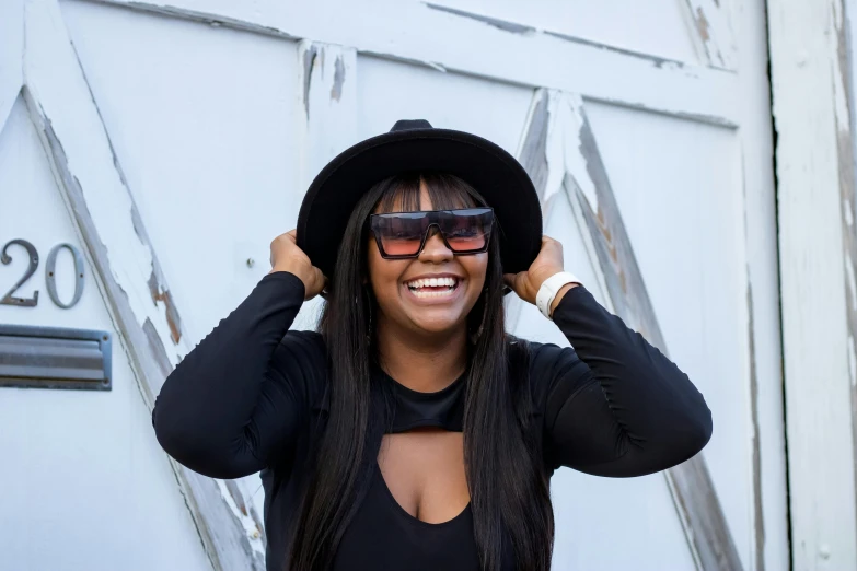 a black woman wearing a hat and sunglasses