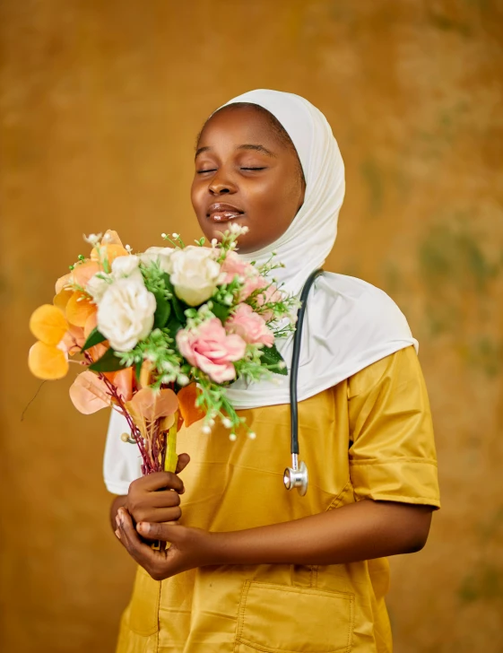 woman wearing a white headdress holding a bunch of flowers