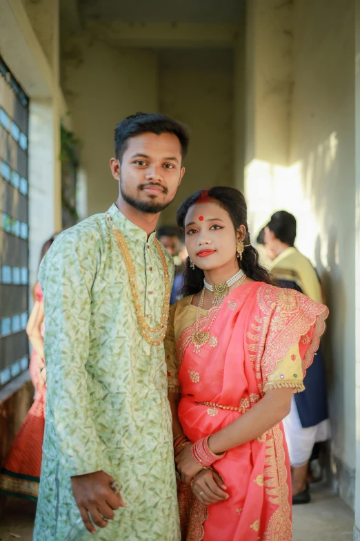 a couple dressed in traditional attire standing next to each other