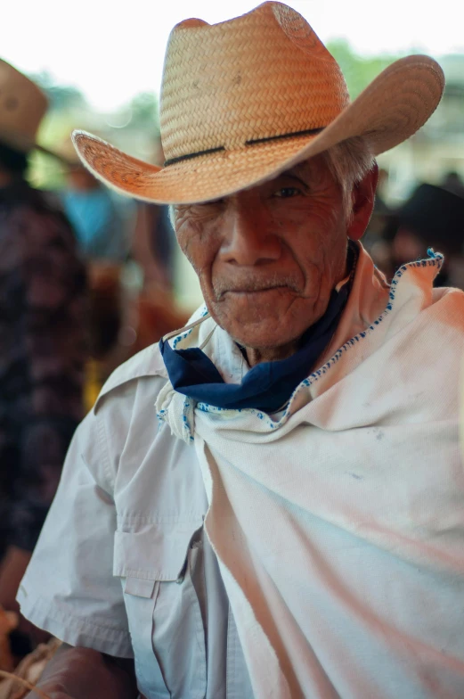 an older man wearing a white shirt and a cowboy hat