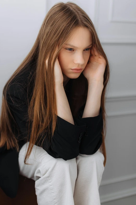 the young woman is sitting down and resting her head on her hand