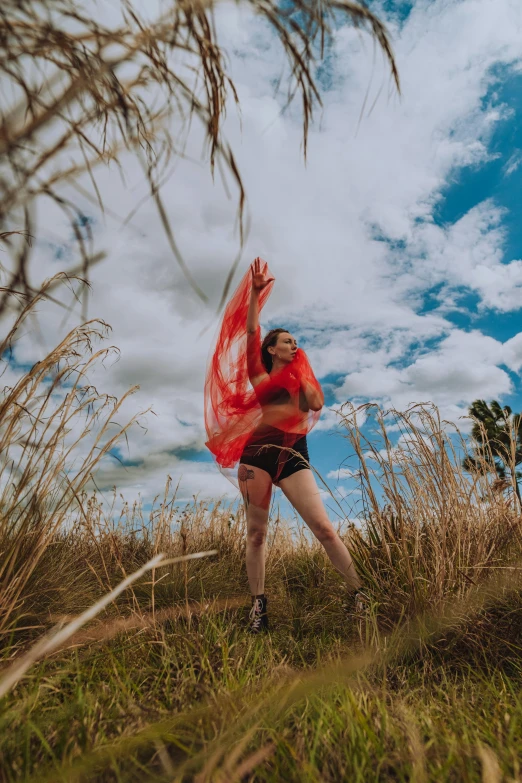 a woman wearing red holding a kite in the air