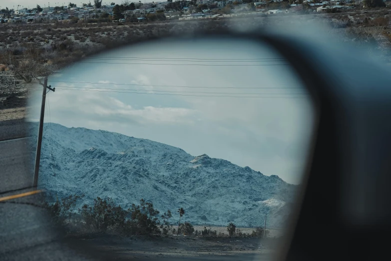 the view through a car window of mountains and telephone lines