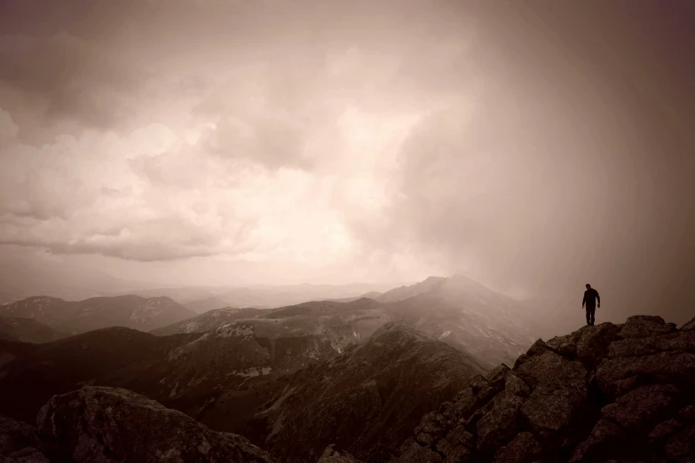 a man stands at the top of a mountain