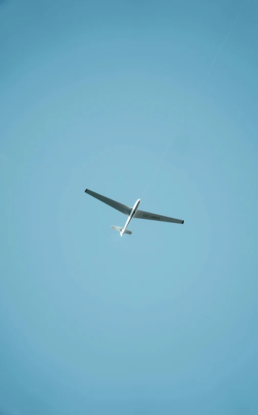 an airplane flies through the air in the blue sky