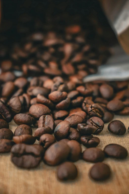 some coffee beans are on top of a wood table