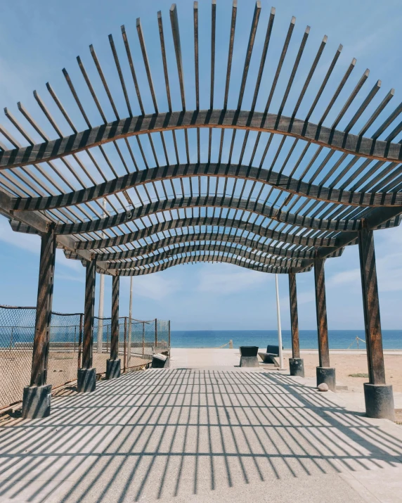 a wooden shelter on the side of the beach