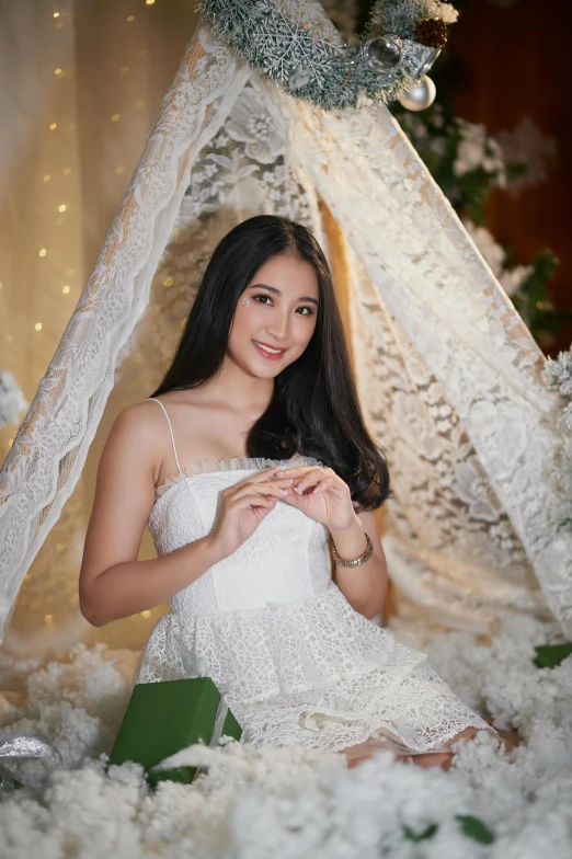 the  poses for a pograph, posing under a lace tent