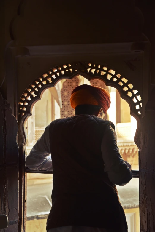 a woman in a turban walks out a doorway