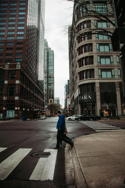 man standing at intersection with a suitcase looking back