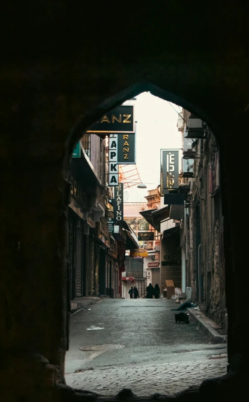 the dark street is next to the neon signs