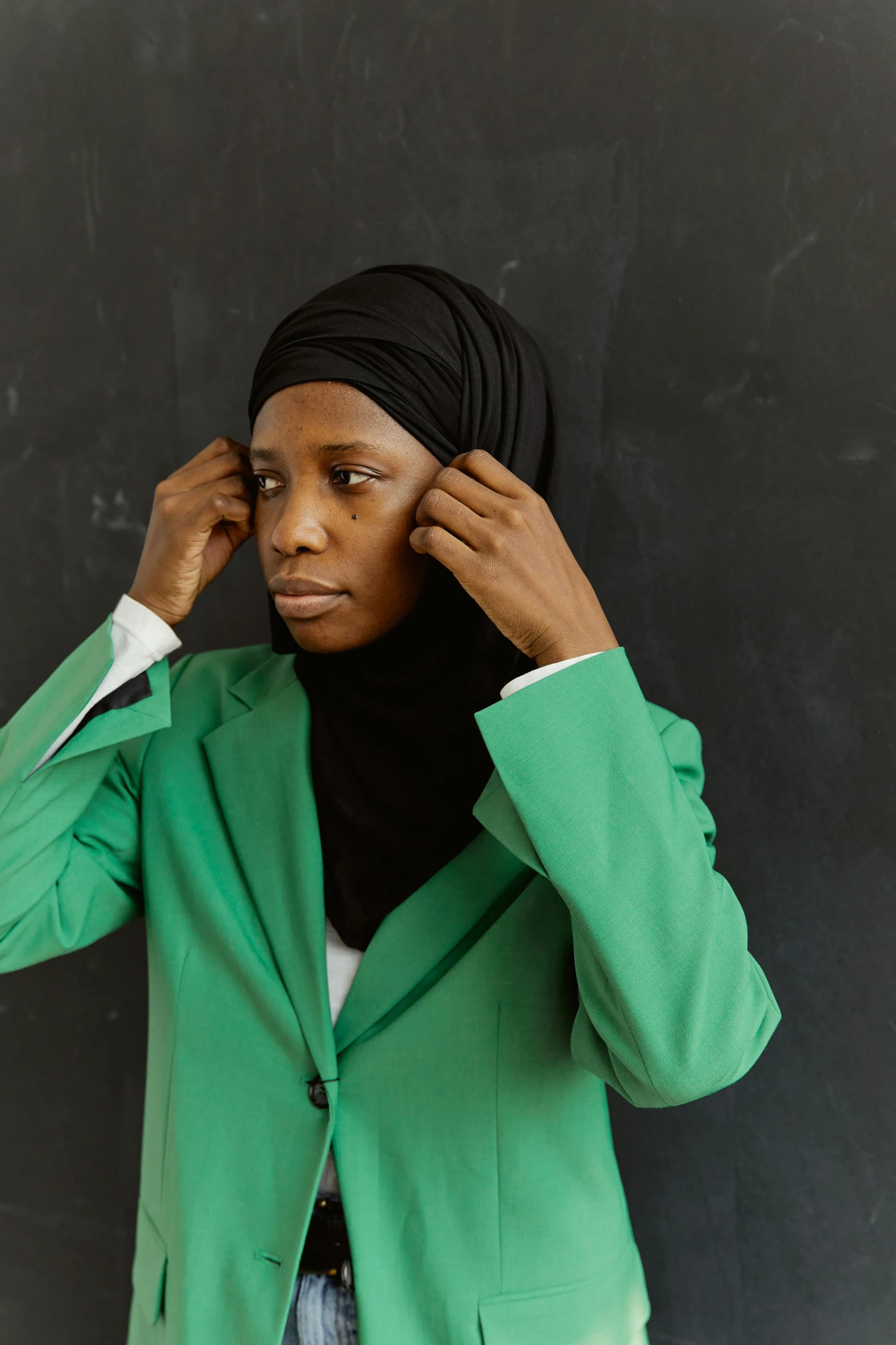 a woman wearing a green jacket is looking down