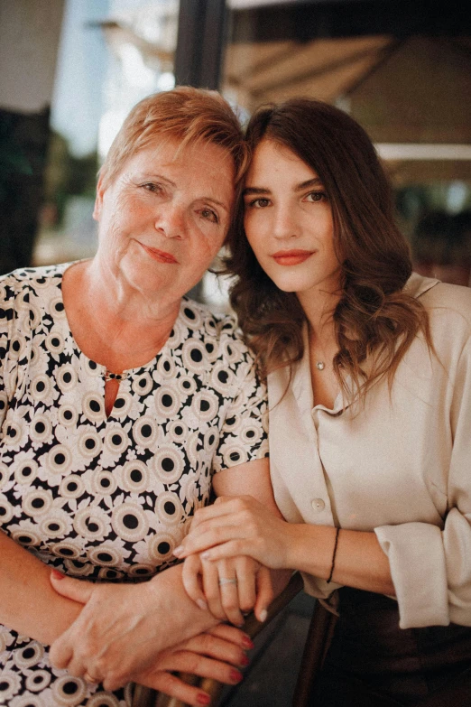 two women sitting together and one is leaning against the arm of the other