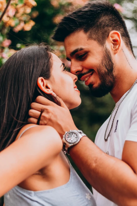 a close up of two people next to a bush