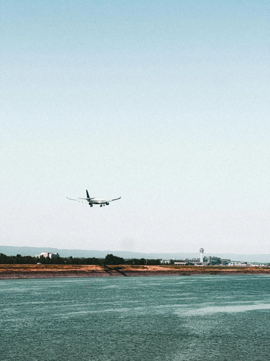 an airplane flies low in the sky next to the water