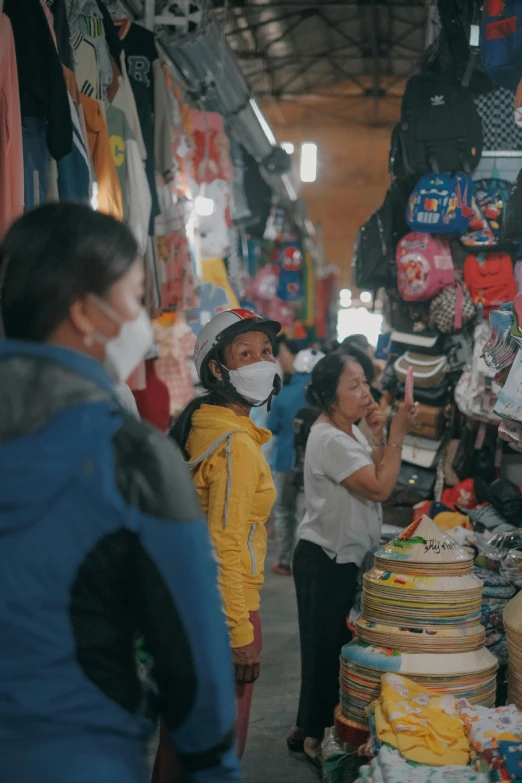 people wearing masks looking for items in the market